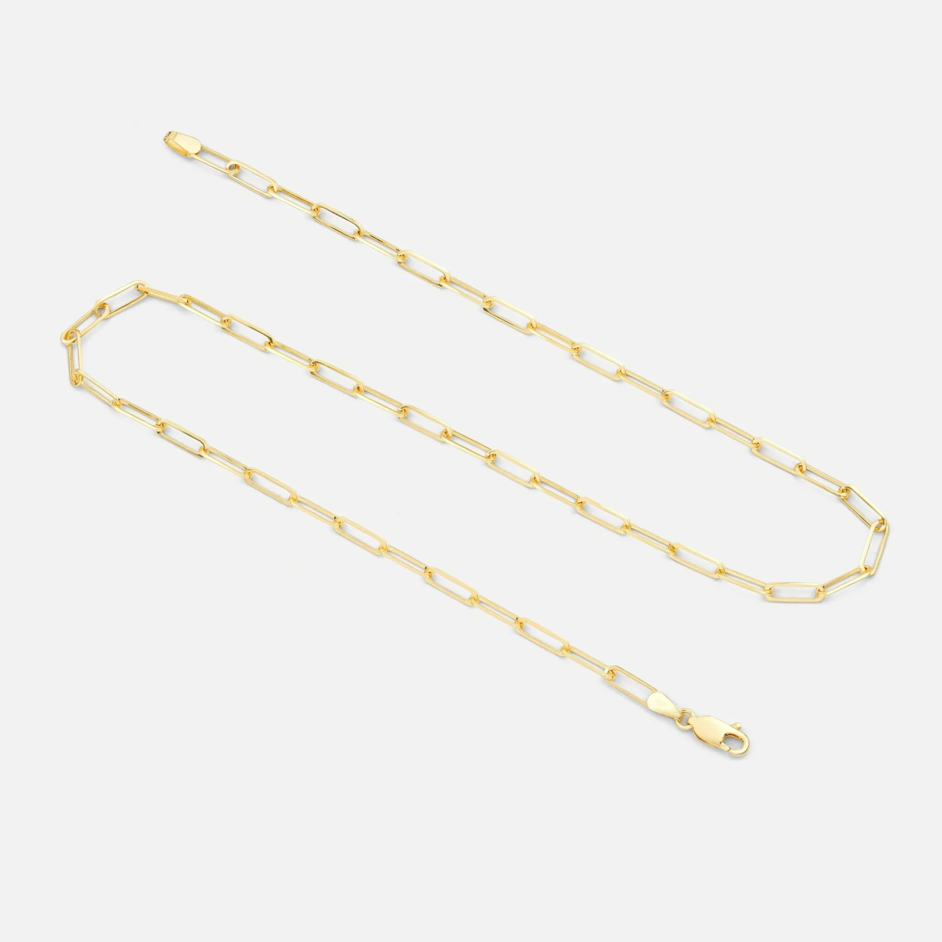 A chain with a gold colored link and a clasp.
